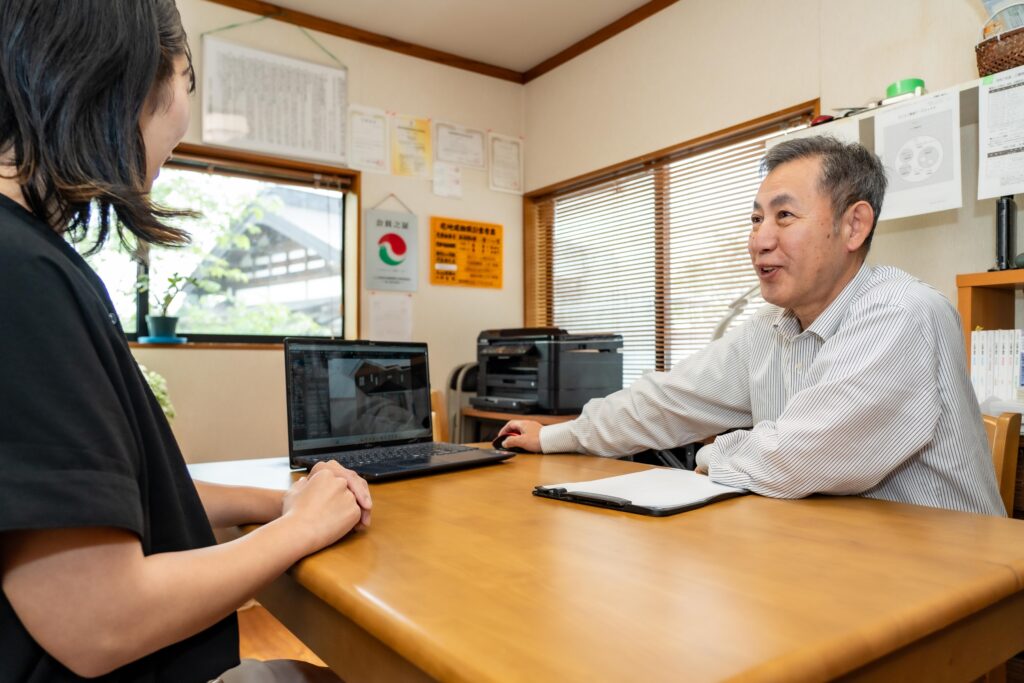 上村和規さんがリフォームプランの図面を広げて説明している様子