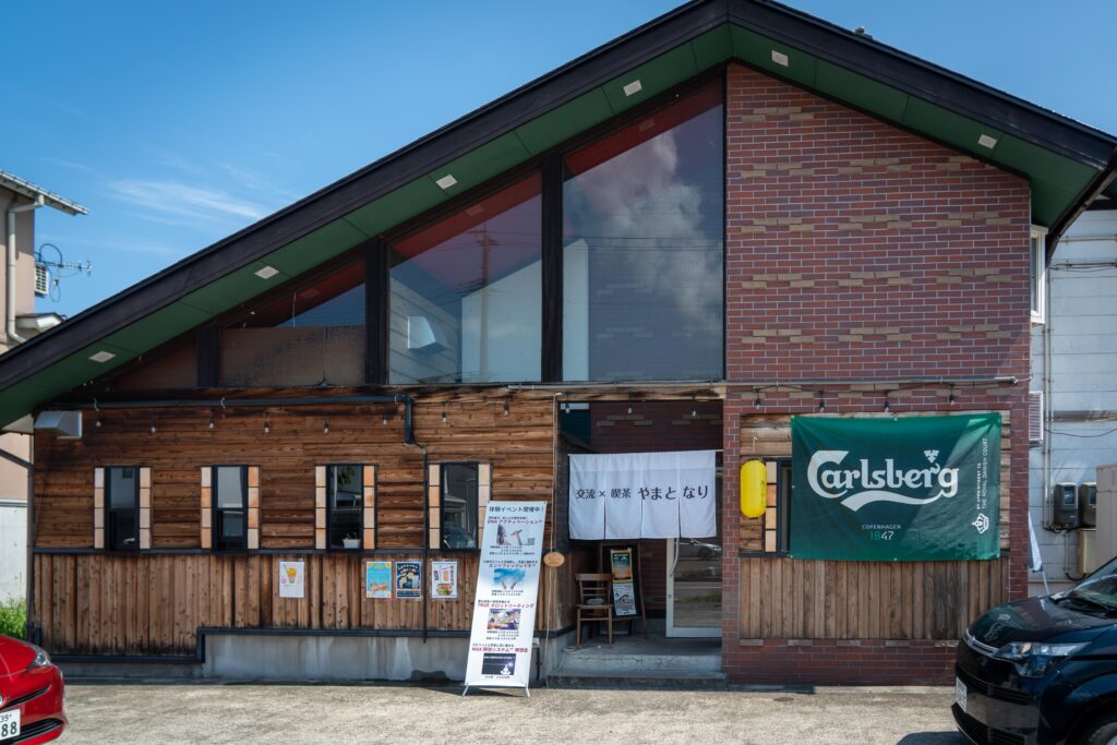 浦佐の「やまとなり」の店舗外観。木とレンガを組み合わせた温もりある建物。
