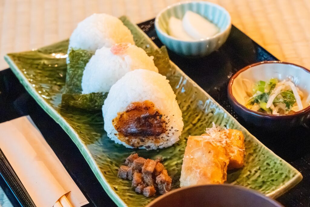 南魚沼市「こめのすけ」の人気メニュー・おむすびセット。塩・鮭・焼き味噌の3種のおにぎりと手づくり副菜が並ぶ、農家直営ならではの定食。