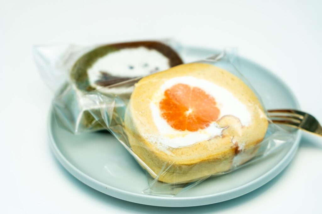 小麦粉を使わず生米から作った「生米ロールケーキ」。断面に大きなみかんが入ったフルーツロールと、濃厚抹茶ほうじ茶ロール。グルテンフリーのスイーツ。