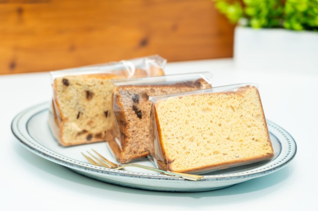 お皿に並んだ3種類のカットシフォンケーキ。定番の濃厚クリーム、チョコチップ入り、季節限定フレーバーなど、きめ細かい断面が特徴。